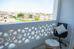 a room with a chair and a window with a view at Malindi White in Malindi