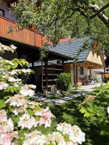 a house with a balcony and flowers in the yard at Princess Mojca Holiday House in Bled