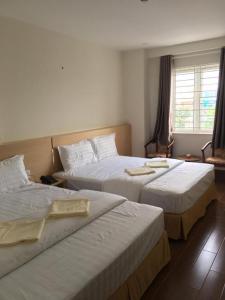 a hotel room with two beds and a window at Phuong Ly Ly in Ho Chi Minh City +35 photos