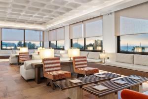 a living room with furniture and large windows at Kouros Palace Active Lifestyle Hotel in Mastihari