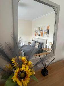 a mirror in a living room with a couch and a flower at Dun-Niall Apartment in Oban