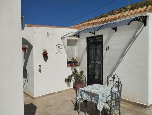 a white house with a table and chairs on a patio at Finca Indalopez in Tabernas