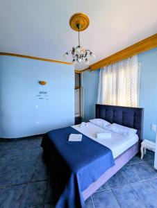a bedroom with a large bed with a blue blanket at Madalenas B&B in Pelekas