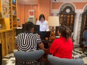 two people sitting at a table in a store with a woman at SAPA DEBOUTIQUE Hotel in Sapa