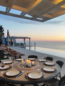 a dining table with candles and a view of the ocean at Okeanos Vine Luxury Villa in Athani