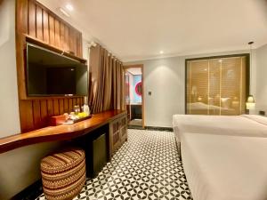 a bedroom with a bed and a desk and a television at SAPA DEBOUTIQUE Hotel in Sapa