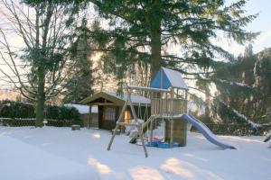 einen Spielplatz im Schnee mit Rutsche in der Unterkunft Haus Bambi in Schulenberg im Oberharz