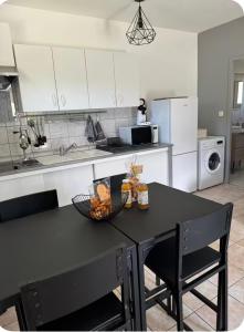 a kitchen with a black table with a bowl of fruit at Mini villa in Corte
