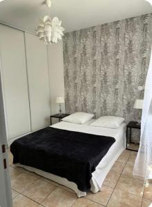 a bedroom with a large bed with a black blanket at Mini villa in Corte