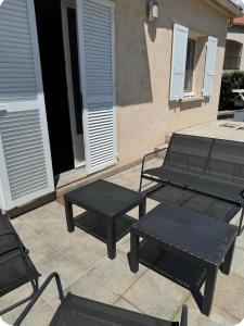 a group of picnic tables and chairs on a patio at Mini villa in Corte