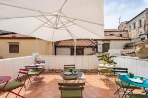 a patio with tables and chairs and an umbrella at Cialoma B&B in Palermo