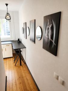 a room with a table and pictures on the wall at Romance Apartments in Panevėžys +7 photos
