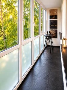 a room with large windows with a table in front of it at Romance Apartments in Panevėžys