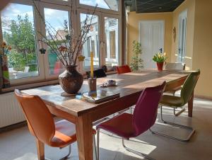 a dining room table with chairs and a vase on it at BnB Het Geluk van Limburg in Mechelen