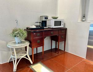 a wooden desk with a microwave and a table with a chair at Song-Jeong Bay Hotel in Busan