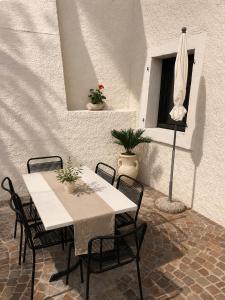 a patio with a table and chairs and an umbrella at Villetta Moscal- Buon Gusto in Affi