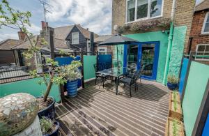 a wooden deck with a table and chairs on a house at High Street Retreat in Whitstable