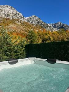 a hot tub with mountains in the background at The Overlook in Bogë