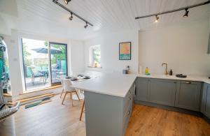 a kitchen with a white counter top and a table at High Street Retreat in Whitstable