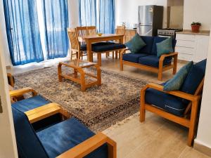 a living room with blue couches and a table at ارضي جنينه قريه التجاريين in Dawwār ‘Abd Allāh