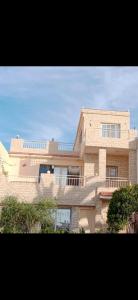 a large brick building with a balcony on it at ارضي جنينه قريه التجاريين in Dawwār ‘Abd Allāh