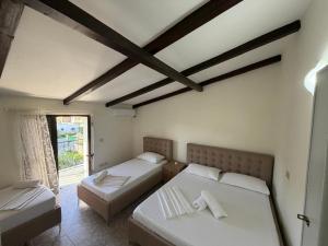 a bedroom with two beds and a window at Villa Emma Durrës in Durrës