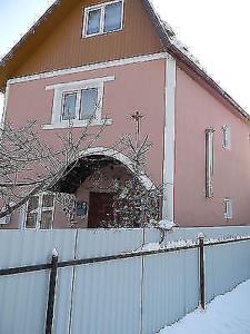 a pink house with a fence in front of it at U Karoliny in Yaremche