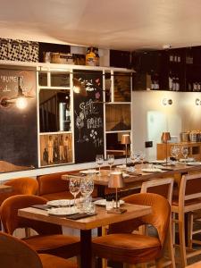 a restaurant with tables and chairs with wine glasses at Hotel du Fronton in Bidart