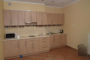 a kitchen with wooden cabinets and a microwave at Gościniec Pan Tadeusz II in Giżycko