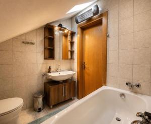 a bathroom with a tub and a sink and a toilet at Gasthaus Sternjak in Wunderstätten