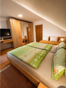 a bedroom with a large bed with a television at Gasthaus Sternjak in Wunderstätten