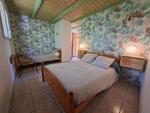 a bedroom with a bed in a room with wallpaper at Les Murmures de la Forêt Bed and Breakfast in Lanas