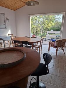 a room with tables and chairs and a large window at Les Murmures de la Forêt Bed and Breakfast in Lanas