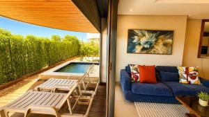 a patio with a blue couch and chairs and a pool at Marina Premium Residences in Casablanca