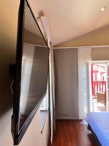 a bedroom with a tv on a wall at Hotel du Fronton in Bidart