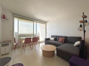 a living room with a couch and a table at Le Grand Large - T2 vue océan in Mimizan-Plage