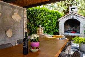 a patio with a table and a stone fireplace at Villa Ferlini in Central Istria with private 10000 m2 garden, wellness & family activities on plot in Svetvinčenat +37 photos