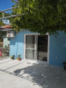 a blue building with a sliding glass door at Mavi Ev in Köyceğiz