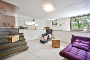 a living room with a purple couch and stairs at Villa Ferlini in Central Istria with private 10000 m2 garden, wellness & family activities on plot in Svetvinčenat