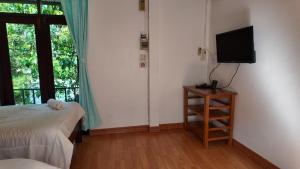 a bedroom with a bed and a tv and a window at Sanfhan Resort-SHA Plus in Khao Chai Son