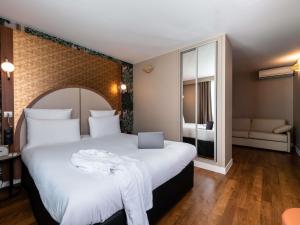 a hotel room with a large bed and a window at Mercure Paris Ouest Saint Germain in Saint-Germain-en-Laye +47 photos