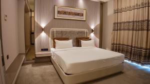 a bedroom with a white bed and a window at Hotel Sea N Rock in Thane