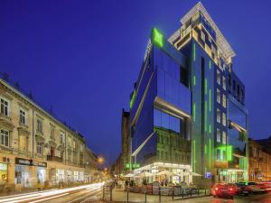 a tall building on a city street at night at Ibis Styles Lviv Center in Lviv