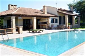 a swimming pool in front of a house at Melpo Estate Kapandriti in Mikrokhórion