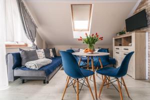 a living room with blue chairs and a table at Szafir Kuźnica - Apartamenty 4 min od plaży in Kuźnica