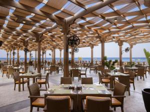 a restaurant on the beach with tables and chairs at Novotel Marsa Alam Beach Resort in Quseir