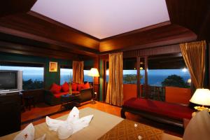 a room with a living room with a large window at Sea Breeze Resort - SHA Plus in Haad Rin