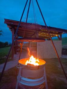 a fire pit with a wooden roof over it at Przystanek Natura in Radzie