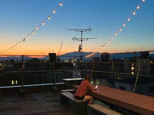 a woman sitting on a bench watching the sunset at TSUKIMI HOTEL in Kyoto