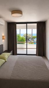 a bedroom with a large bed and a large window at Amalia Apartments in Polis Chrysochous +27 photos